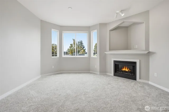 a view of an empty room with window and fire place