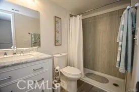 a bathroom with a granite countertop sink toilet and shower