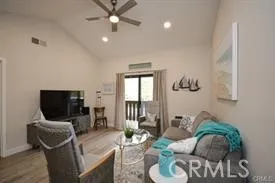a living room with furniture a flat screen tv and a window