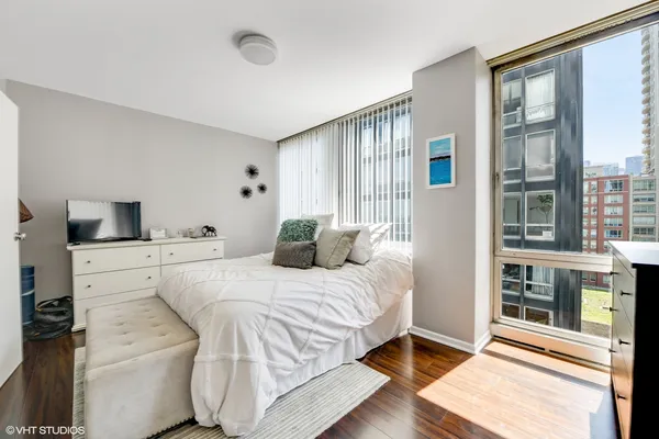 a bedroom with a bed and a large window