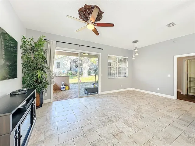 a dining room filled a chandelier and kitchen view
