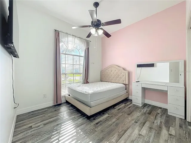 a bedroom with a bed and a ceiling fan