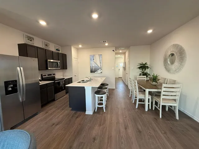 a kitchen with a table chairs stainless steel appliances and cabinets