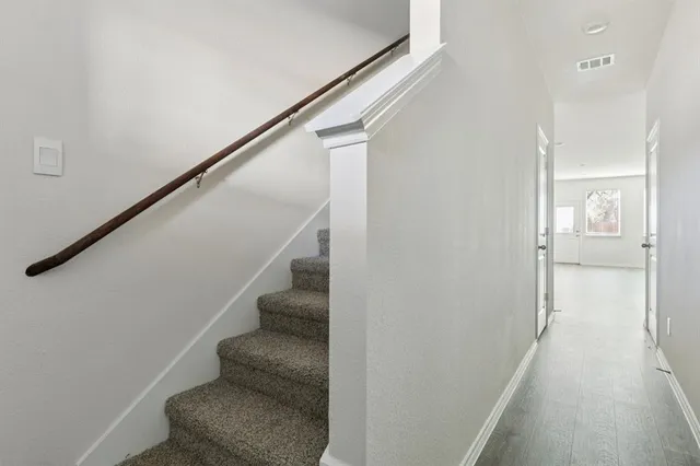 a view of hallway with stairs and wooden floor