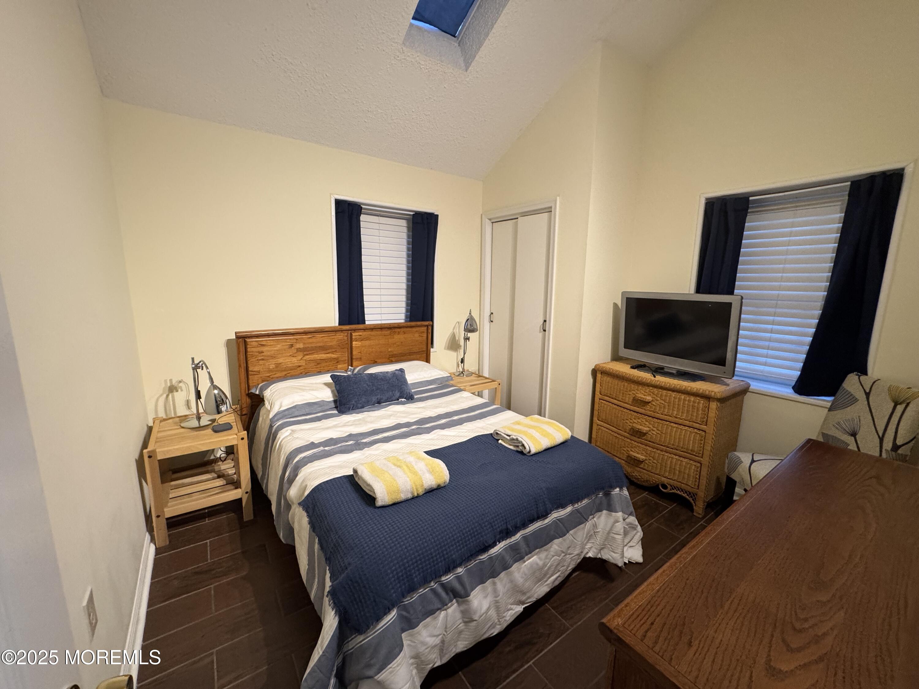 124 Lincoln Avenue, Unit 4 Seaside Heights, NJ 08751 - Photo 7 of 14 a bedroom with a bed and flat screen tv