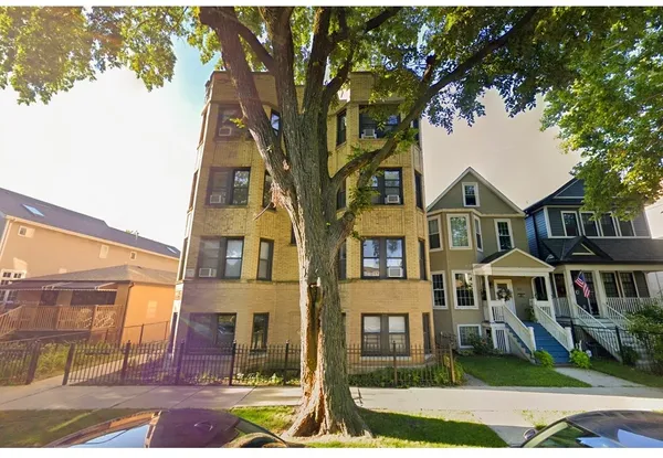 a front view of a residential apartment building with a yard
