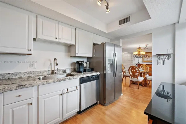 a kitchen with white cabinets and refrigerator