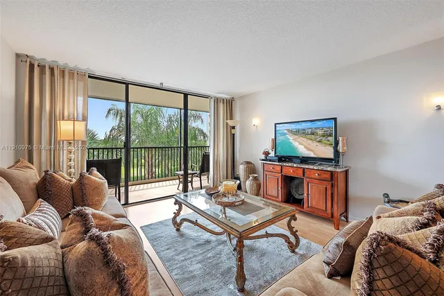 a living room with furniture a large window and a flat screen tv