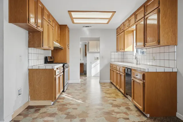 a kitchen with stainless steel appliances granite countertop a stove a sink and a microwave