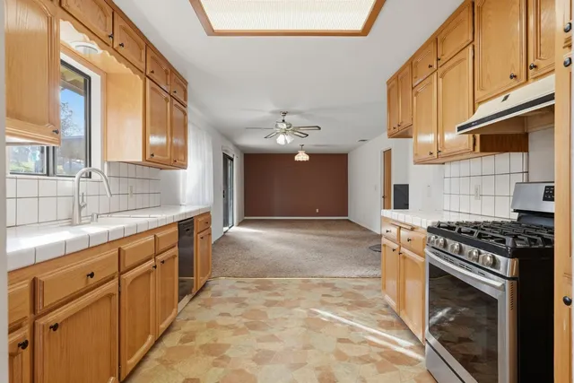 a kitchen with stainless steel appliances granite countertop a sink and cabinets with wooden floor