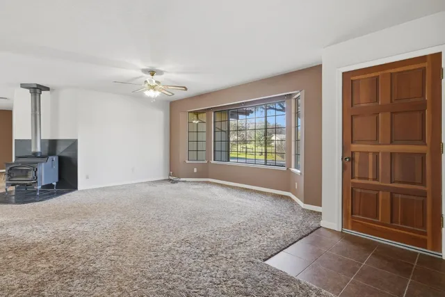 an empty room with windows chandelier fan and windows