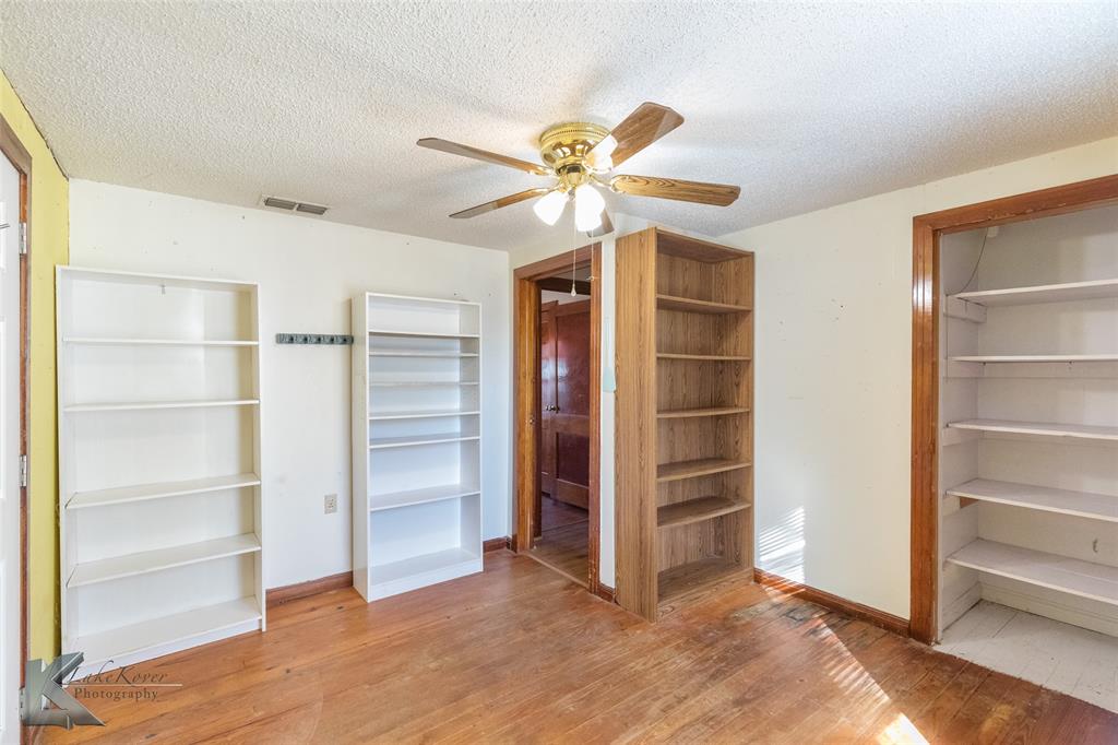 405 South Hinton Street Benjamin, TX 79505 - Photo 4 of 40 Unfurnished bedroom featuring a closet, a textured ceiling, light wood-style flooring, and ceiling fan
