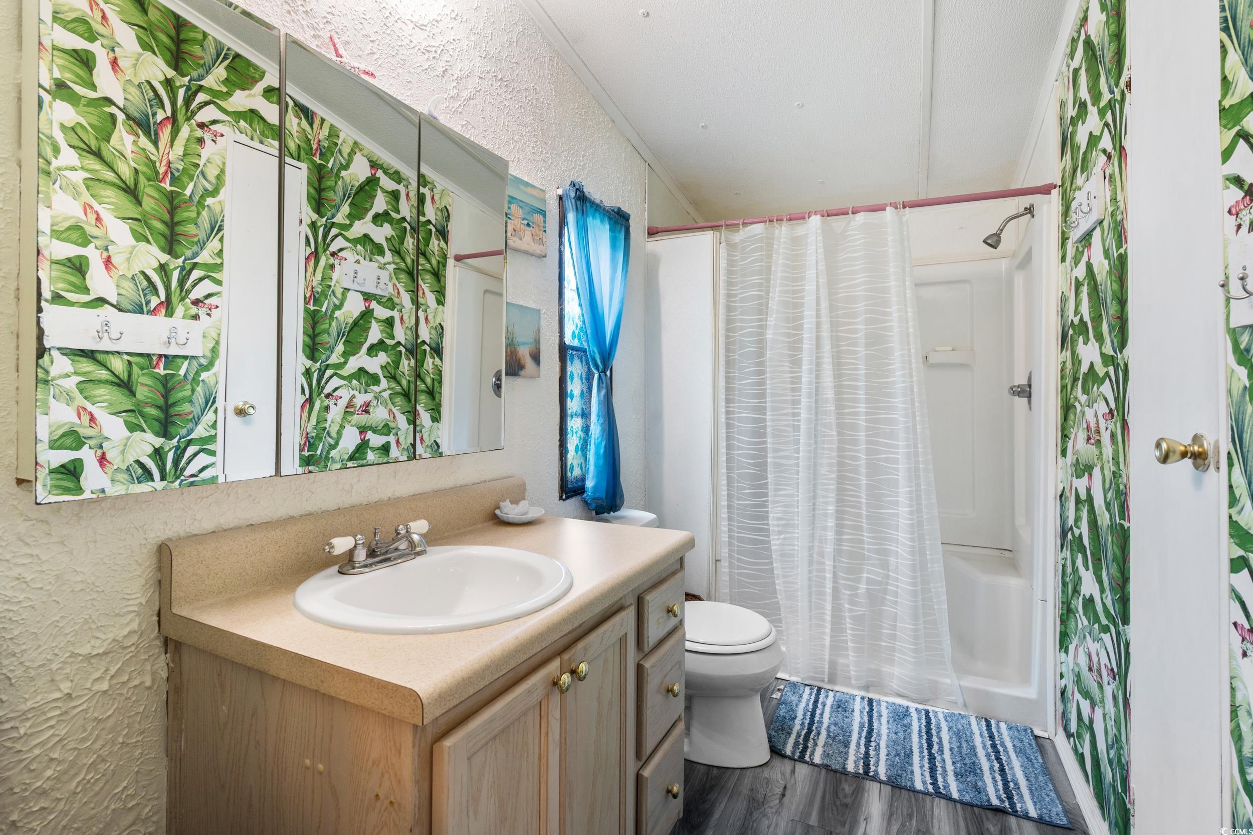 17 Crooked Island Circle Murrells Inlet, SC 29576 - Photo 18 of 39 Bathroom featuring vanity, toilet, a textured wall, wood finished floors, and a shower with shower curtain
