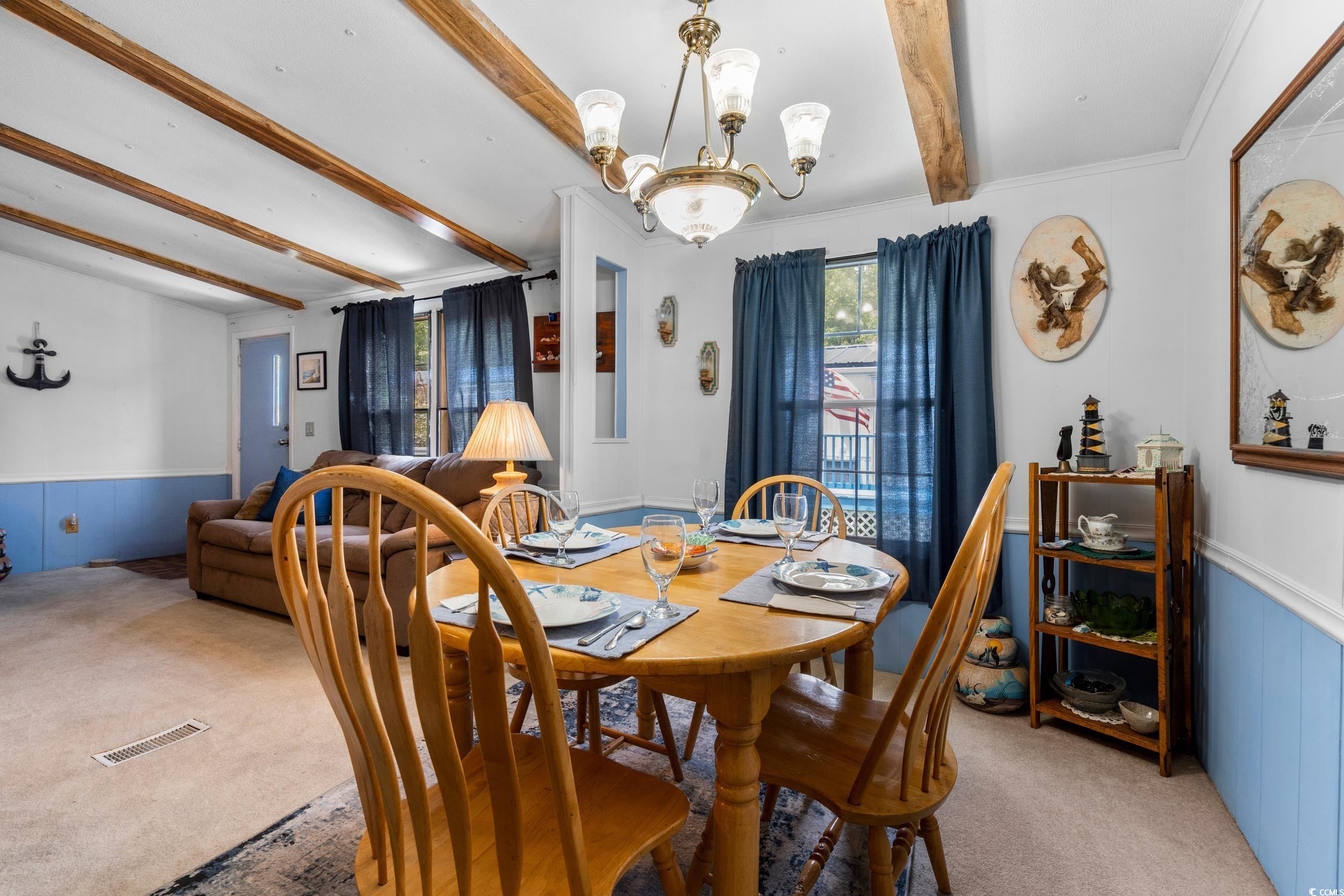 17 Crooked Island Circle Murrells Inlet, SC 29576 - Photo 8 of 39 Dining room with beam ceiling, light carpet, a chandelier, wainscoting, and crown molding