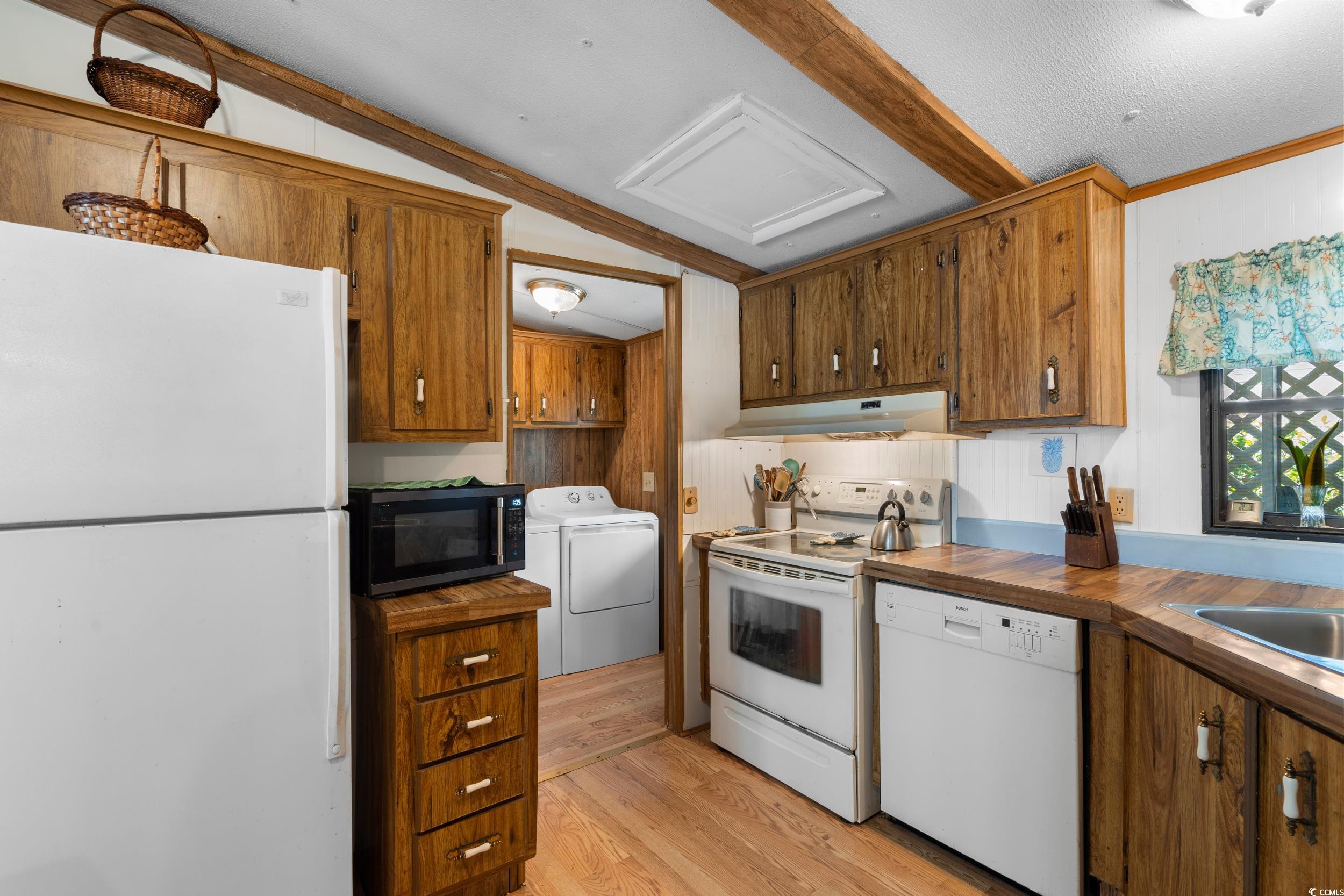 17 Crooked Island Circle Murrells Inlet, SC 29576 - Photo 10 of 39 Kitchen with white appliances, under cabinet range hood, light wood-style floors, brown cabinets, and wooden counters