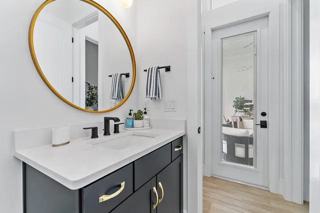 a bathroom with a granite countertop sink toilet a mirror a vanity and shower