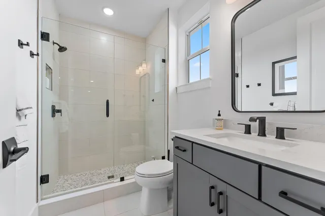 a kitchen with stainless steel appliances granite countertop a stove a sink dishwasher and white cabinets with wooden floor