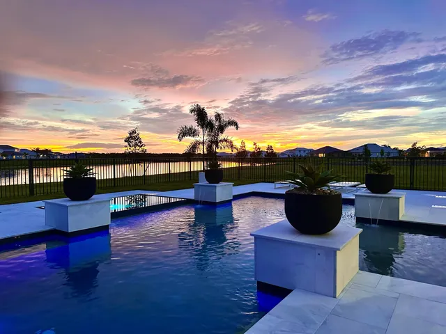 a dining room with wooden floor a chandelier a wooden table and chairs