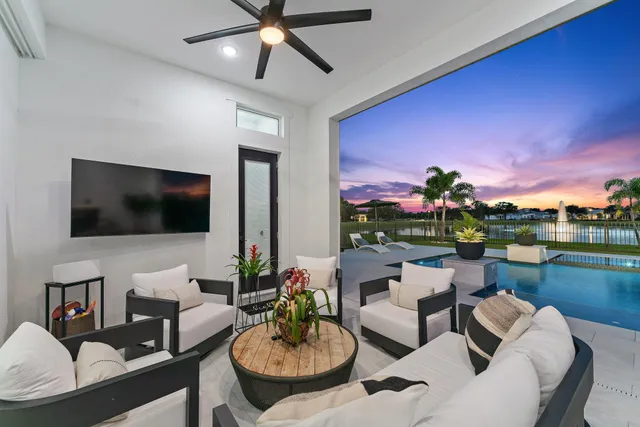 a living room with furniture a flat screen tv and a large window