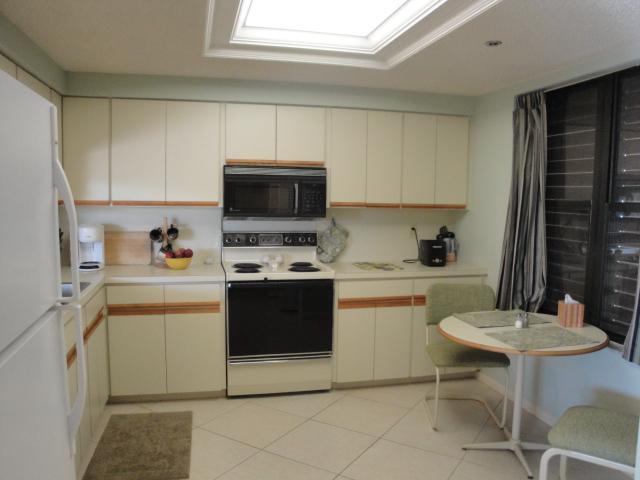 221 Northeast Plantation Road, Unit 415 Jensen Beach, FL 34957 - Photo 4 of 6 a kitchen with a sink cabinets and appliances