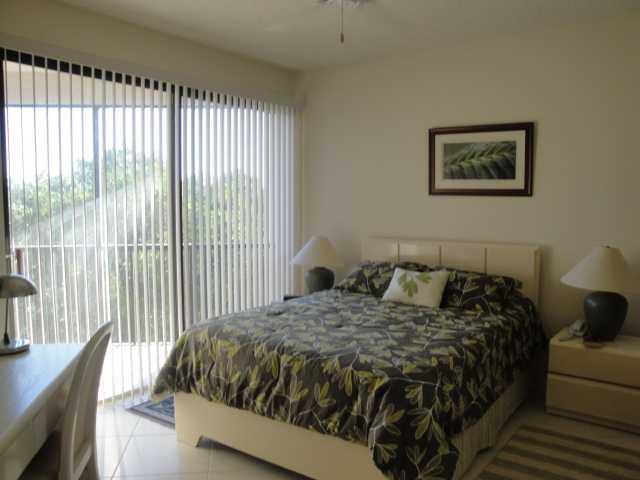 221 Northeast Plantation Road, Unit 415 Jensen Beach, FL 34957 - Photo 5 of 6 a bed sitting in a bedroom next to a window