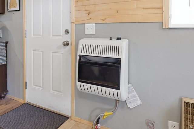 2345 East Frampton Hts Road, Unit 12 Fillmore, UT 84631 - Photo 12 of 31 Wall-mounted heating unit with a white finish, positioned beneath a light wood-paneled wall and a window