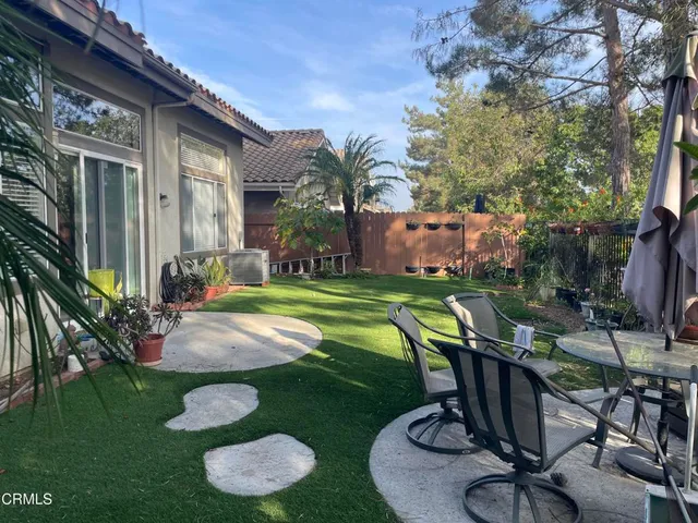a view of a backyard with plants and patio