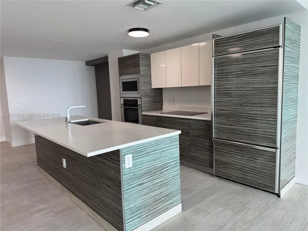 a kitchen with kitchen island a sink stainless steel appliances and cabinets