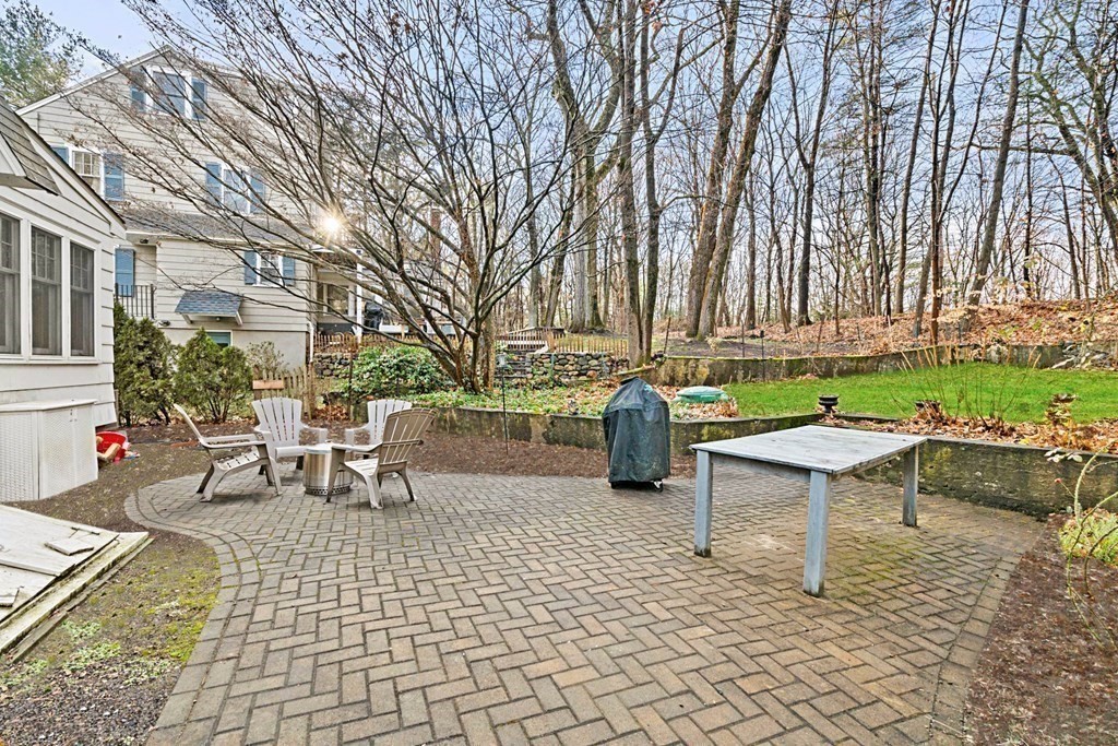 47 Beverly Road Newton, MA 02461 - Photo 14 of 19 a view of a patio with table and chairs couches under an umbrella with large trees