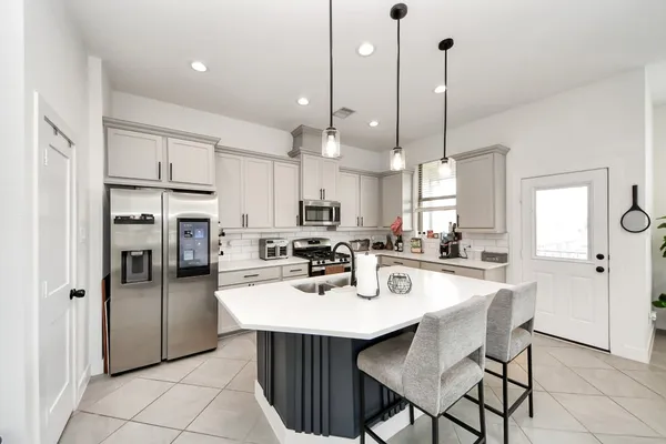 a kitchen with stainless steel appliances a center island refrigerator and cabinets