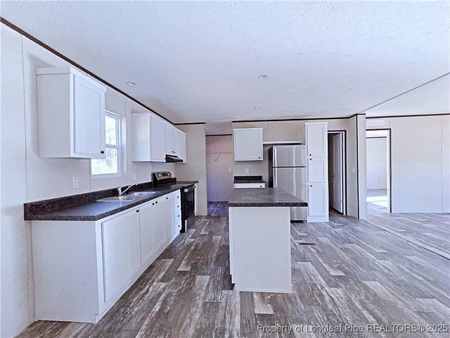 a kitchen with stainless steel appliances granite countertop a stove and a refrigerator