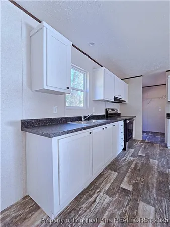 a kitchen with stainless steel appliances granite countertop a sink stove and cabinets
