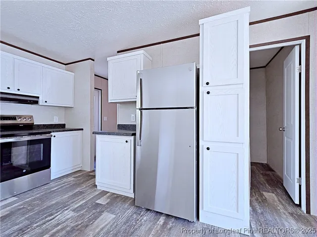 a kitchen with stainless steel appliances a refrigerator and a stove top oven