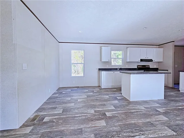 a view of a kitchen with microwave and windows