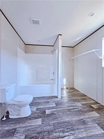 a hallway with white cabinets and wooden floor