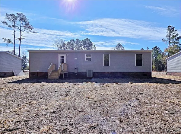 a view of a house with wooden deck and a backyard