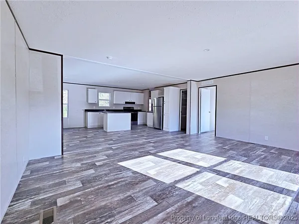 a view of a room with a refrigerator and a table