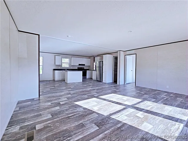 a view of a room with a refrigerator and a table