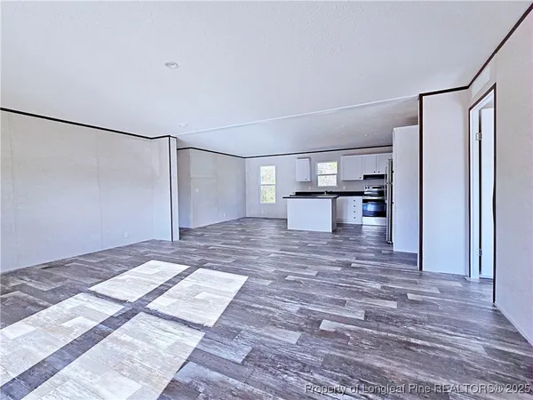 a view of empty room with a fireplace and wooden floor