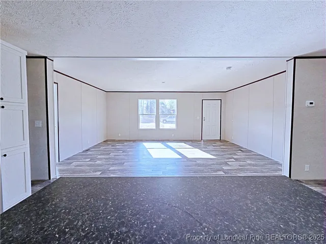 an empty room with windows and closet