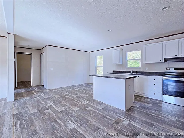 a view of kitchen with granite countertop cabinets and wooden floor