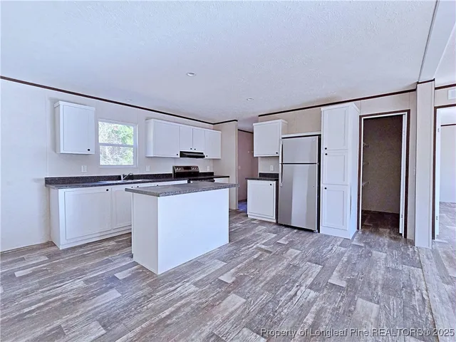 a kitchen with white cabinets and refrigerator