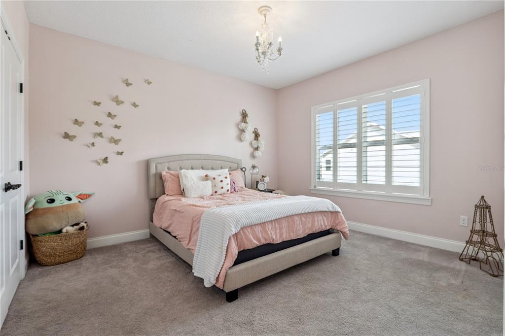 352 Moonbeam Loop Oviedo, FL 32765 - Photo 32 of 64 a bed sitting in a bedroom next to a window and a chair