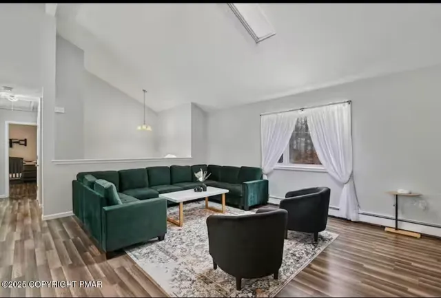 a living room with furniture and a wooden floor