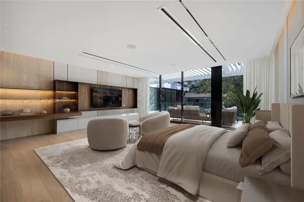 a bedroom with a bed a couch and potted plant