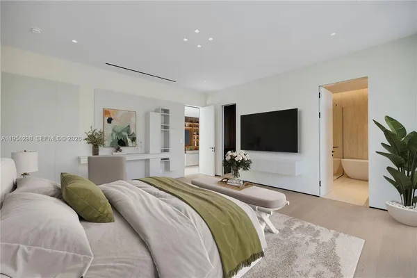 a bedroom with a bed a flat screen tv and a couch