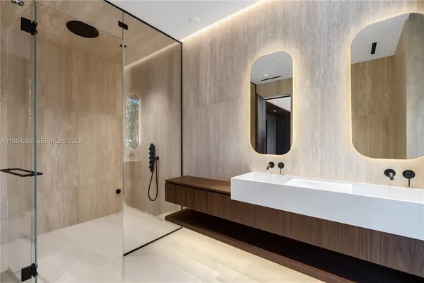 a bathroom with a double vanity sink mirror and bathtub
