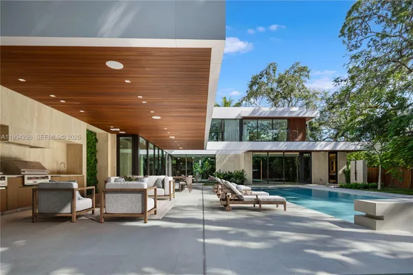 a patio with a table and chairs under an umbrella with a fire pit