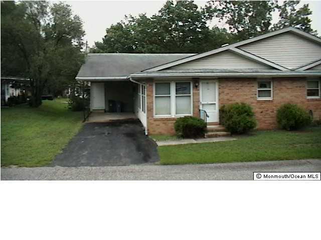 18 Sycamore Road, Unit D Manahawkin, NJ 08050 - Photo 1 of 1 a front view of a house with a garden and plants