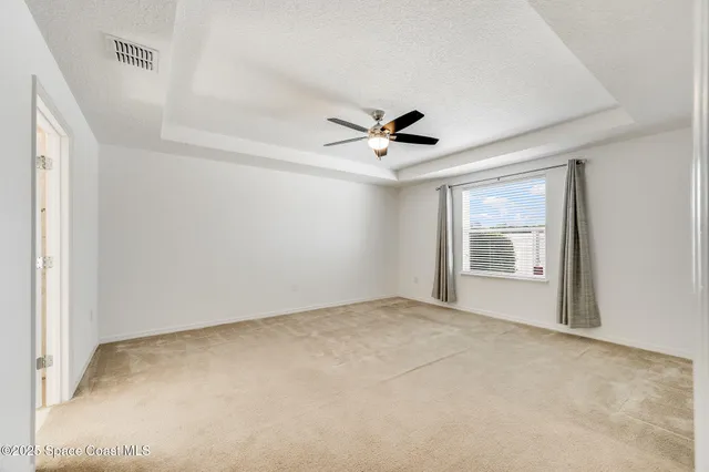a bathroom with a granite countertop double vanity and a mirror